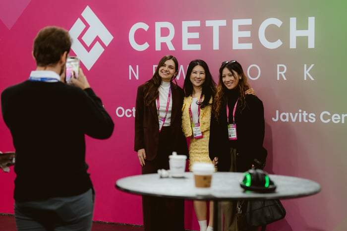 Attendees meeting at the CREtech backdrop
